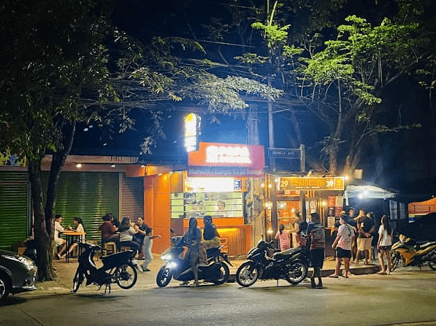 A Papa Burger branch trading at night, motorbikes parked outside.