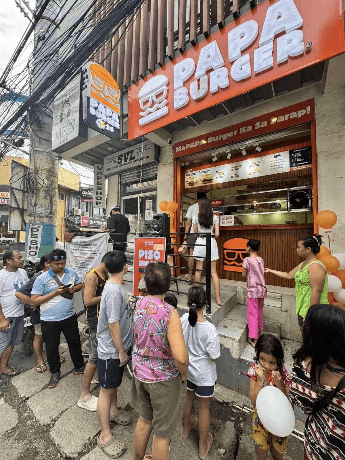 Families waiting at a Papa Burger counter in the afternoon.