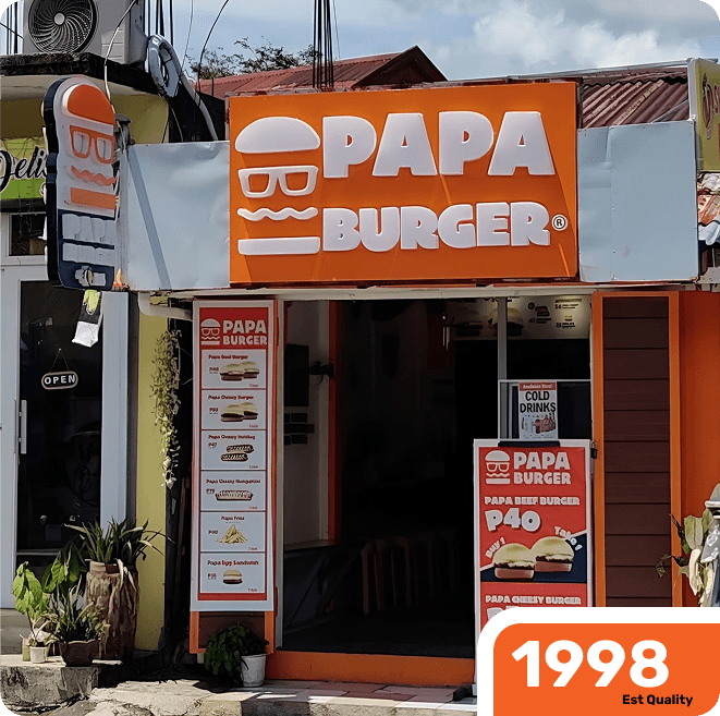 A Papa Burger storefront carrying the 1998 mark beside its menu board.